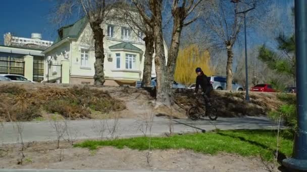 Junger BMX-Fahrer springt mit Drehung über Rohr im Skatepark. — Stockvideo