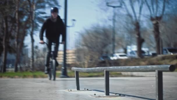 CLose upp av unga bmx ryttare hoppar genom röret på skate park. — Stockvideo