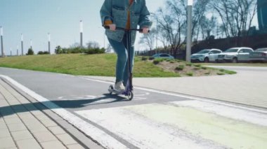 Bir yaz parkında mobiletle gezen kot pantolonlu kadınların bacaklarını kapat.