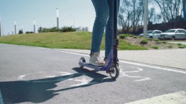 Bir yaz parkında mobilete binen kadınların bacaklarını kapatın.