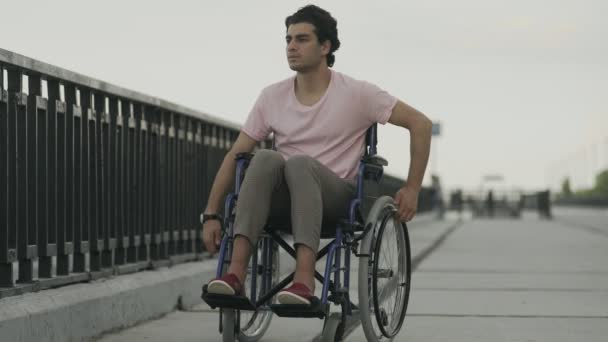 Triste disabili su sedia a rotelle guardare il fiume e lasciare via — Video Stock