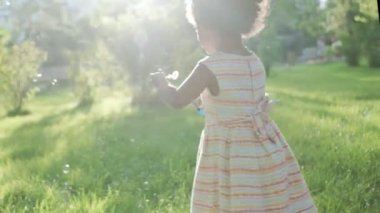 Kafasında pamuk helva olan Afro-Amerikalı bir kıza yakın durun.