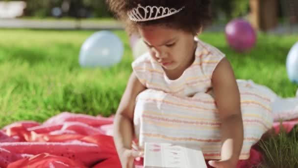 Happy Little menina afro-americana jogar com caixa de presente em seu aniversário — Vídeo de Stock