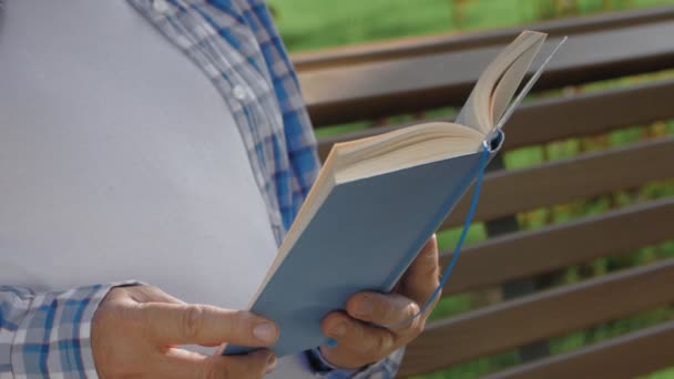 Primer plano de un hombre mayor leyendo en el parque — Vídeos de Stock