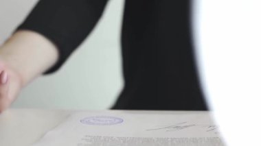 Sözleşmeye ya da belgelere onaylı damga koyan kadın eli.