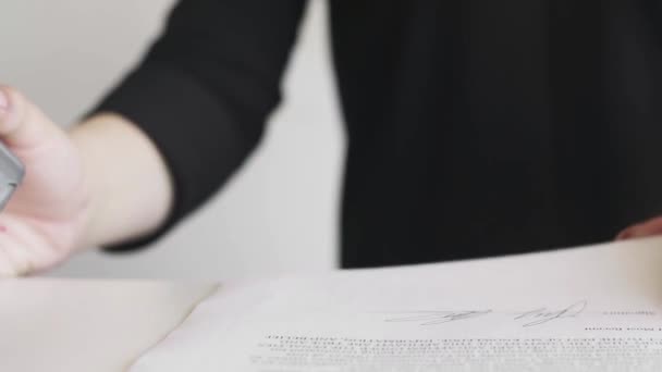 Mão feminina que coloca um carimbo negado no contrato ou documentos . — Vídeo de Stock