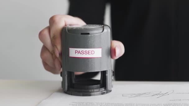 Close up of Female hand that puts an PASSED stamp in the contract or documents. — Stock Video
