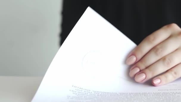 Kvinnlig hand som sätter en attesterad stämpel i kontraktet eller dokumenten. — Stockvideo