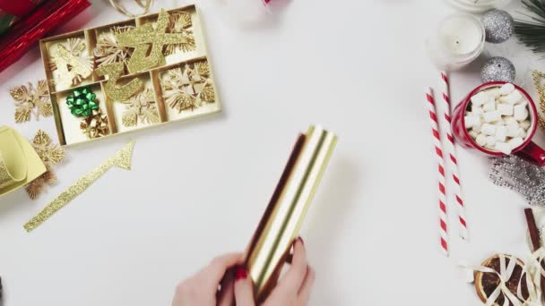 Γυναίκα προετοιμασία χαρτί για την περιτύλιξη Χριστουγεννιάτικα δώρα — Αρχείο Βίντεο