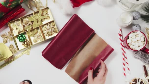 Mulher cortando papel vermelho para embrulhar presentes de Natal — Vídeo de Stock