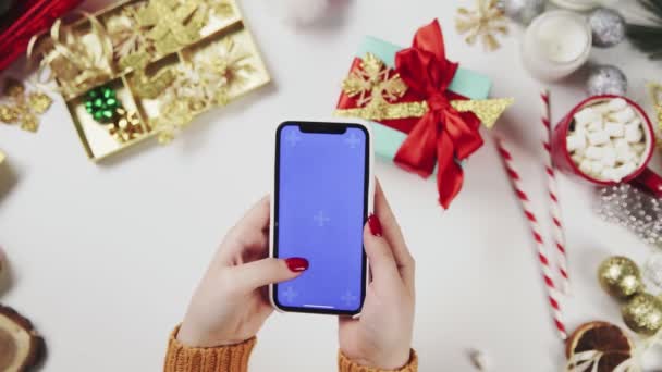 Manos de vista superior utilizando la pantalla táctil del teléfono móvil gestos táctiles múltiples Tecla de croma en la mesa de Navidad — Vídeos de Stock