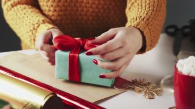 Tanımlanamayan Kadın Noel Hediyelerini Masada Noel süslemesiyle Açıyor.