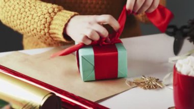 Tanımlanamayan Kadın Noel Hediyelerini Masada Noel süslemesiyle Açıyor.