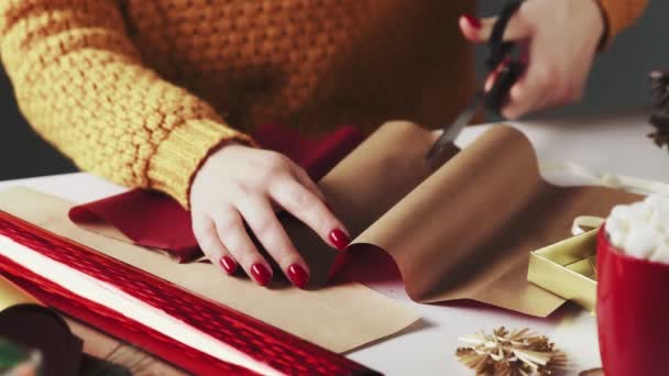 Woman cutting red paper to wrapping Christmas Presents On Table With Christmas Decoration. — Stock Video