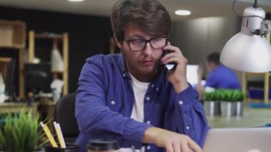 Mutlu genç adam telefonda konuşuyor ve EVET hareketi yapıyor.