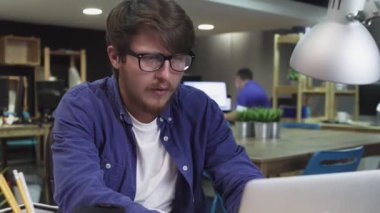 Ofisteki bilgisayarda çalışan genç programcı