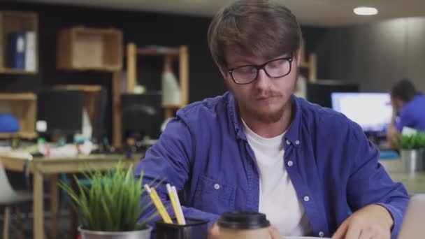 Молодий чоловік пише нотатки на липких різнокольорових наклейках, використовуючи ручку — стокове відео