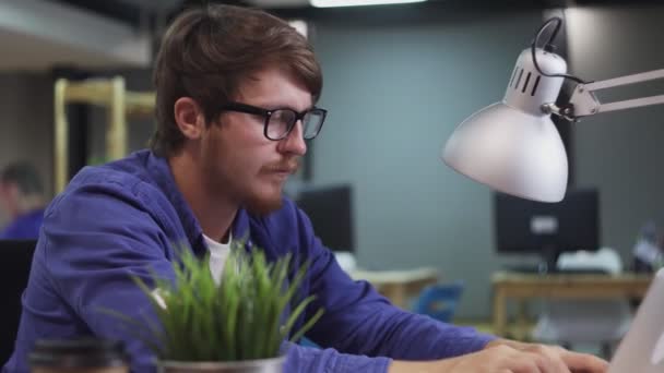 Движение программиста Долли, работающего на компьютере в офисе — стоковое видео