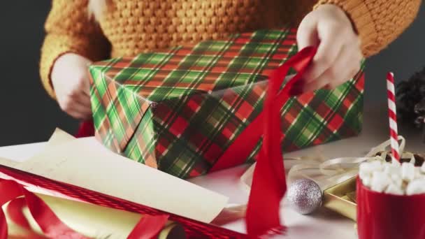 Mujer irreconocible atando cinta roja en regalo de Navidad — Vídeo de stock