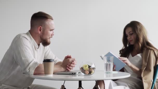 Couple businesspeople sitting in cafe. young couple discussing a new book — Stock Video