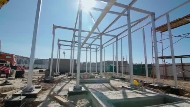 Trabalhadores da construção civil estão construindo uma estrutura metálica. Desenvolvimento de novos locais de construção — Vídeo de Stock