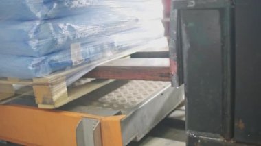 Yükleyici çantaları taşır. Depo. Palet.