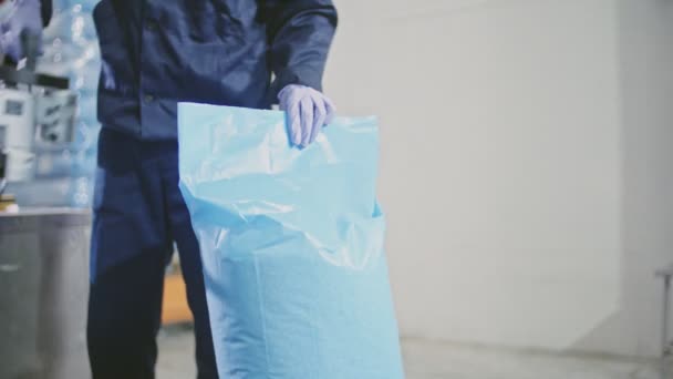 Worker packing blue bag with boiled rice — Stock Video