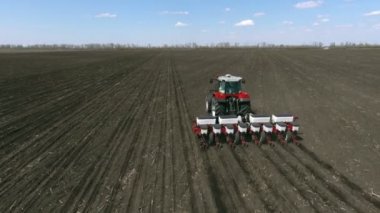 Tarımsal traktör ekiyor ve ekiyor.