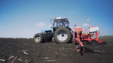 Tarımsal traktör ekiyor ve ekiyor.