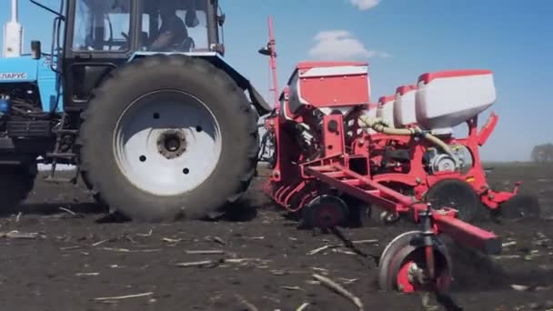 Traktor med speciella precisionssåmaskiner, frösådd arbetar i fält, jordbruksmaskiner planterar majs eller solrosfrön i nyplöjd mark. — Stockvideo