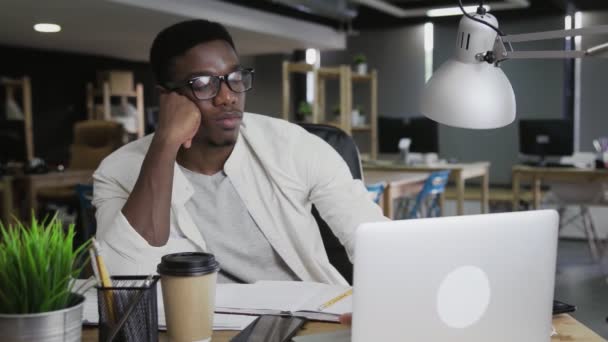 Homme africain fatigué de travailler sur ordinateur portable et d'attendre la fin de la journée de travail — Video
