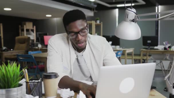 Muž pracující na obchodním projektu a procházení on-line při poslechu hudby. Afro-americký muž tančí v kanceláři — Stock video