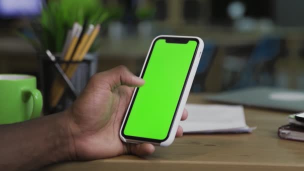 Back close-up visning af afro mand surfer på nettet ved hjælp af mobiltelefonen med grøn skærm . – Stock-video