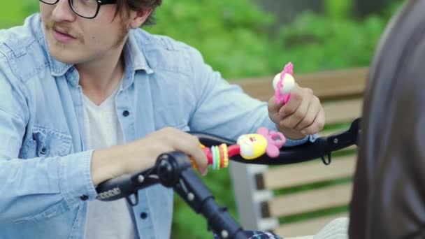 Close-up van vader spelen met rammelaar speelgoed, kalmeren baby naar beneden — Stockvideo