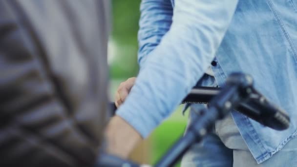 Ung far matar barnet från mjölkflaskan i stadsparken — Stockvideo