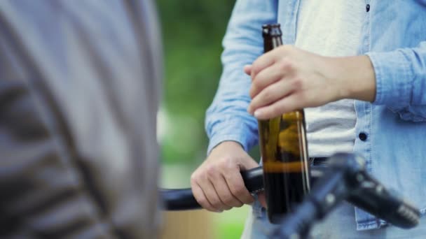 Close-up van mans hand met bier en kinderwagen in het park — Stockvideo