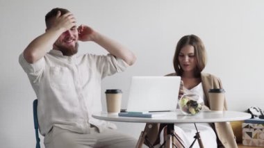 Ortak çalışma alanında konuşan mutlu bir çift. Yakından gülümseyen adam açık alanda oturan bir kızla flört ediyor. İş yerindeki arkadaşına gülümseyen güzel kız..