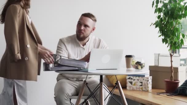 Manager bracht aan mannelijke werknemer een heleboel mappen met documenten — Stockvideo