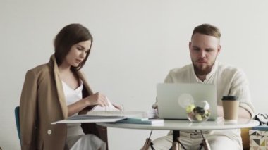 Not defteri ve iş kadını üzerinde çalışan bir iş adamı birlikte çalıştığı belgelerle çalışıyor.