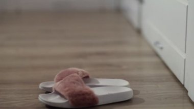 Yataktan çıkan kadın, terliklerini giy.