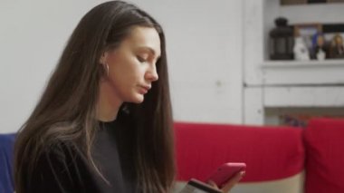 Güzel bir kadın internet üzerinden akıllı telefonundan alışveriş yapmak için kredi kartı kullanıyor.
