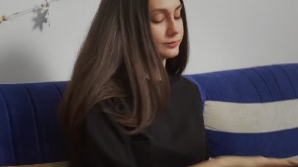 Jeune femme d'affaires travaillant à la maison sur ordinateur portable assis dans un canapé confortable. Blogueuse indépendante travaillant à la maison avec ordinateur portable. Journaliste blogueur travaille à distance.