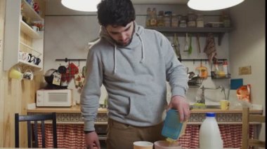 Genç bir adam mutfakta kahvaltı hazırlıyor.