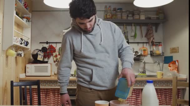 Mladý muž vaří snídani v kuchyni. — Stock video