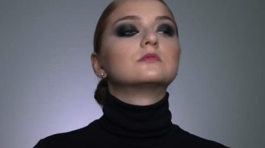 Makyaj sanatçısının güzellik salonunda genç bir bayana profesyonel makyaj yapması. Makyaj sanatçısı, siyah bir gölgenin dumanlı gözlerini güzel bir modelin özel fırçasıyla yapar