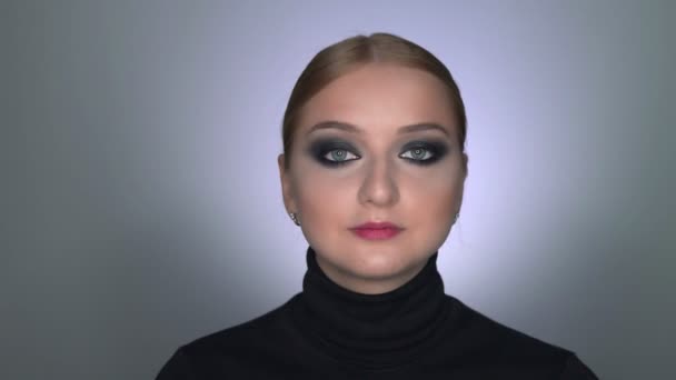 Hermosa mujer con maquillaje ojos ahumados posando en la cámara — Vídeo de stock