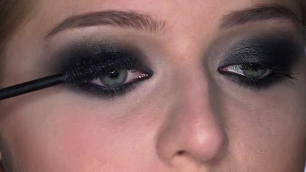 Boční pohled make-up umělce dělat profesionální make-up pro mladou ženu v beauty studiu. Make up Umělec maluje řasy řasy řasenka — Stock video