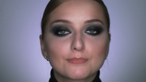 Mooie vrouw met make-up rokerige ogen poseren bij de camera — Stockvideo