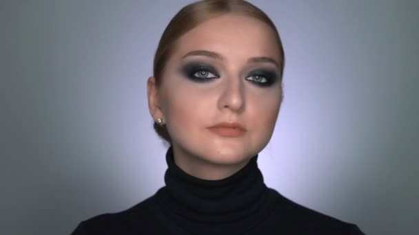 Gyönyörű nő smink füstös szemmel pózol a kamera előtt — Stock videók