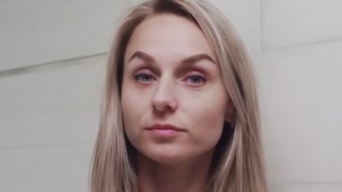 Kadın losyon sürüyor ve kameraya bakıyor.